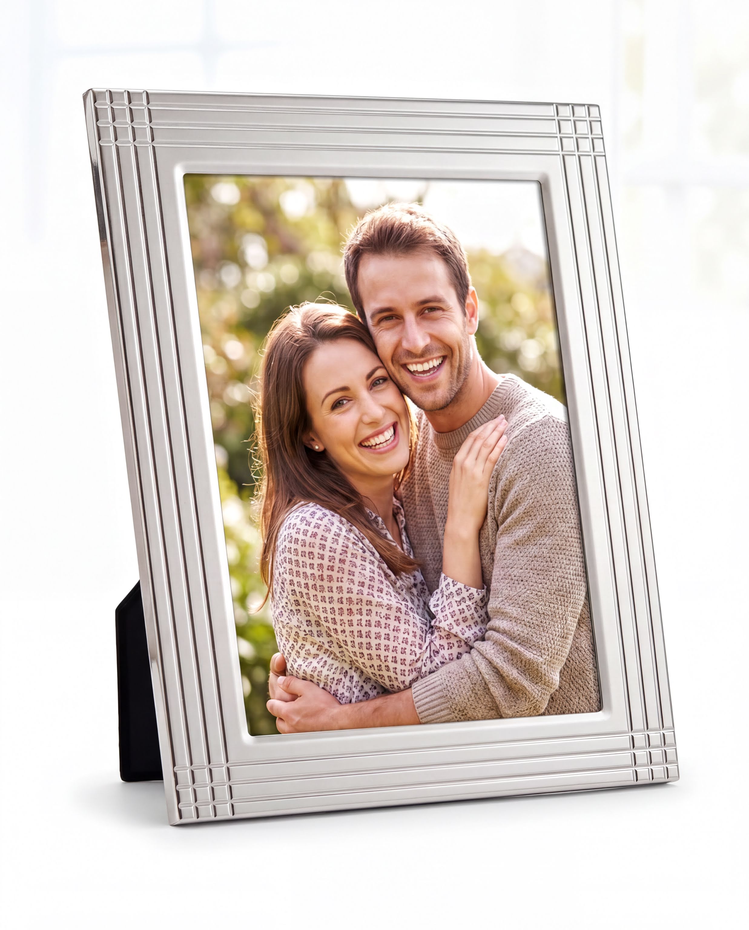 A happy couple embracing each other in a silver picture frame.