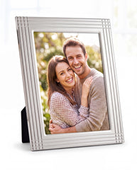 A happy couple embracing each other in a silver picture frame.