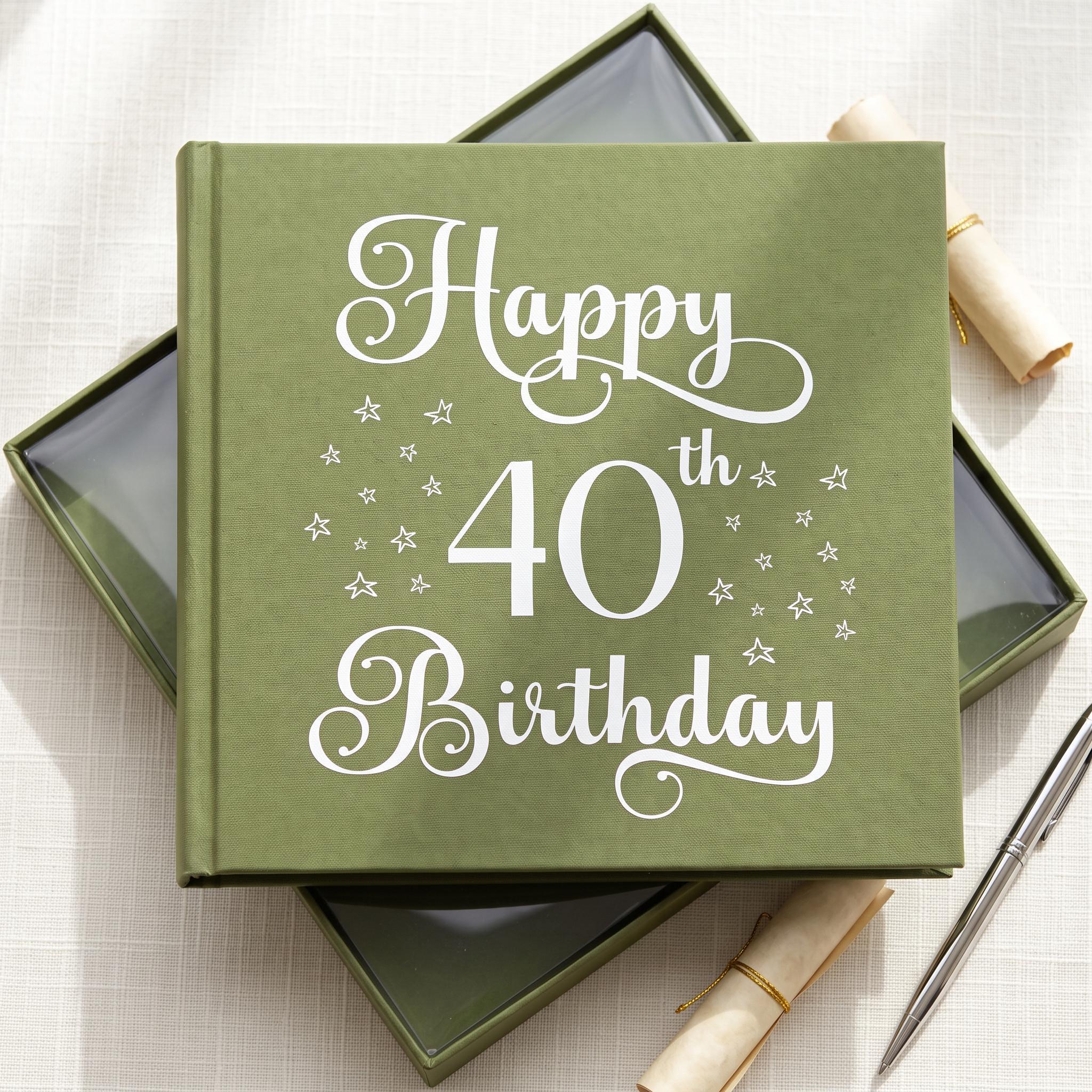 A green book titled "Happy 40th Birthday" with white text and stars on the cover, placed on a white surface next to a pen and a rolled-up paper.