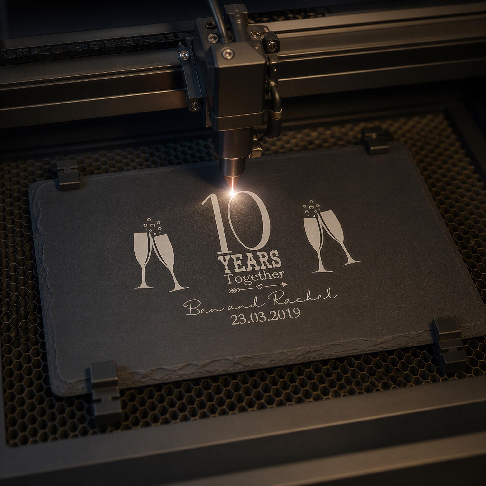 A black slate with a laser engraving of a champagne glass and the text "10 YEARS TOGETHER" and "Ben and Rachel 23.03.2019" on it.