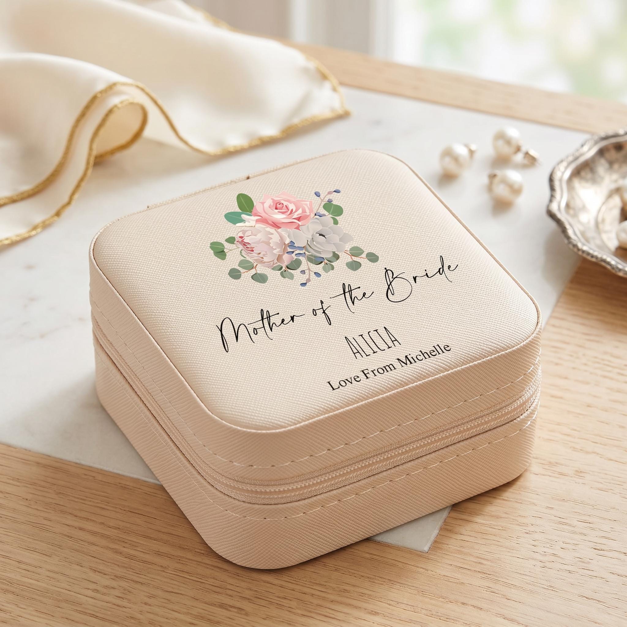 A beige jewelry case with a floral design and text that says "Mother of the Bride" and "Alicia Love From Michelle".