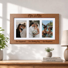 A wooden picture frame with three photographs of a couple, including a bride and groom, a bride and groom, and a bride and groom in a pool. The frame has the text "Mrs and Mrs" written on it.