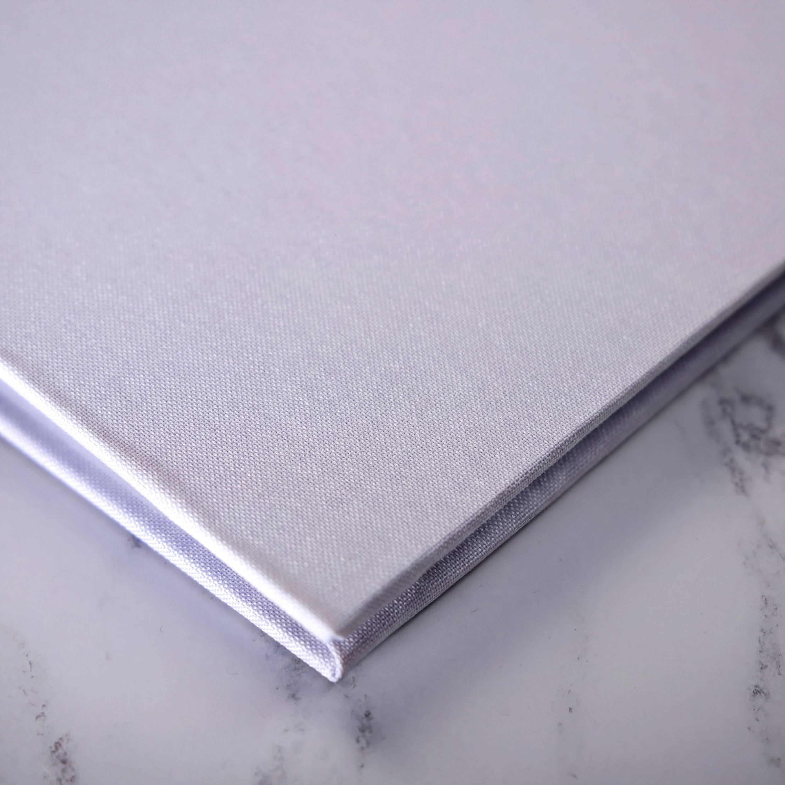 A close-up view of a white, textured surface, possibly a marble or stone, with a folded or closed object placed on top of it.