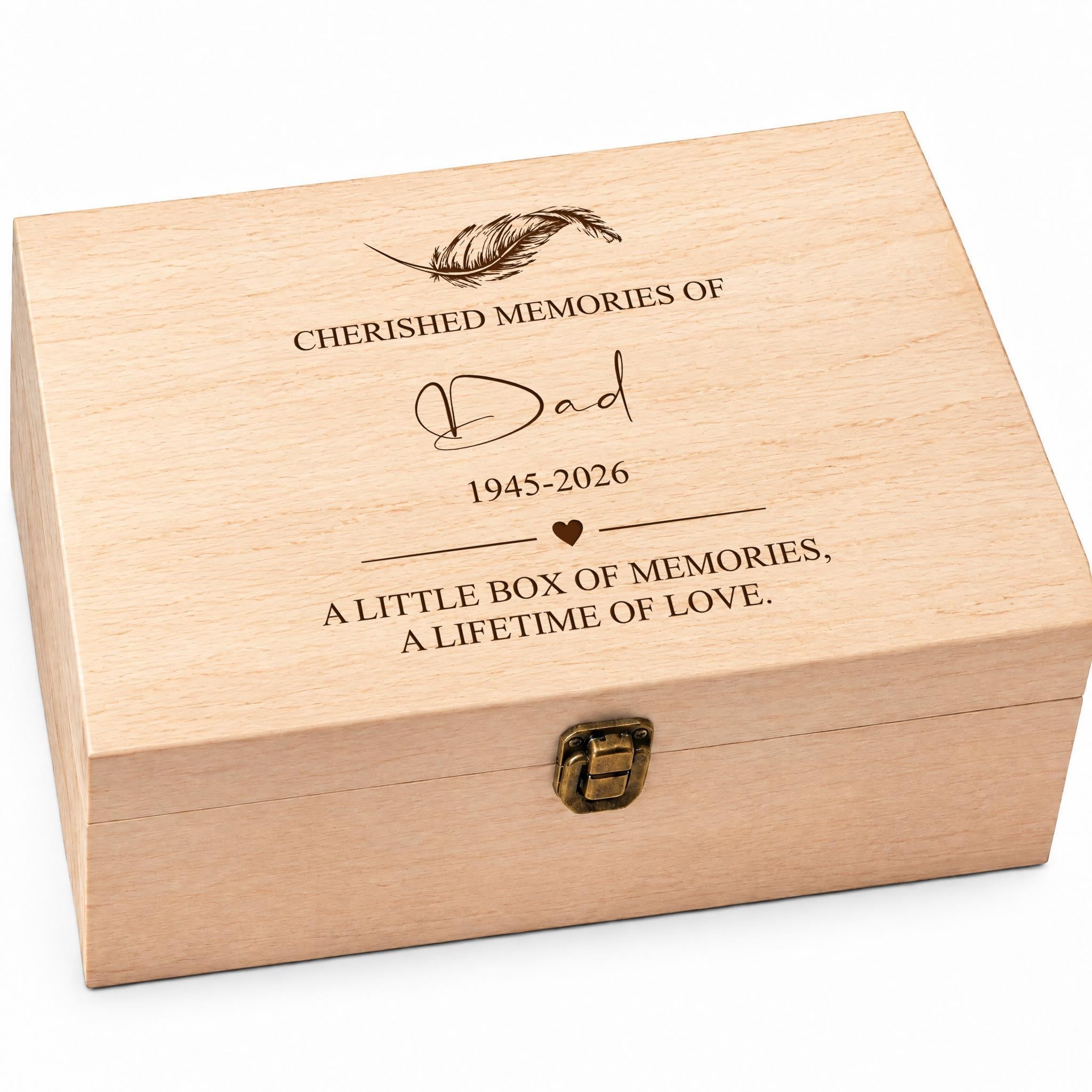 A wooden box with a lid, engraved with the text "CHERISHED MEMORIES OF Dad 1945-2026 A LITTLE BOX OF MEMORIES, A LIFETIME OF LOVE" and a feather design.