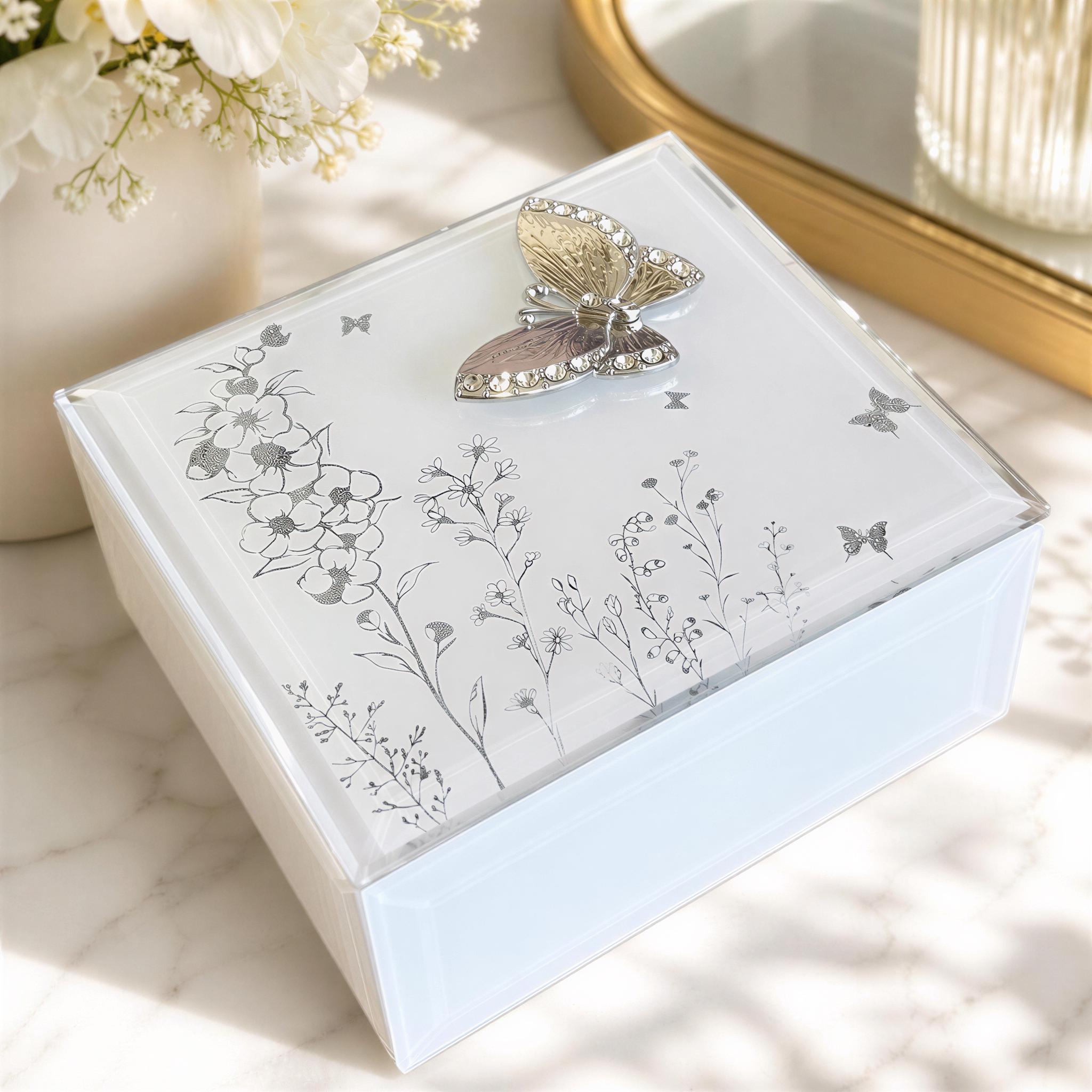 A decorative box with a butterfly motif and floral designs, placed on a marble surface.