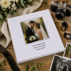 a wedding album with a photograph of a bride and groom, surrounded by wedding-related items such as a camera, a bouquet of flowers, and other wedding-related items.
