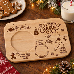 A wooden tray with a personalized message and various holiday-themed items, including gingerbread cookies, a glass of milk, and Christmas decorations.