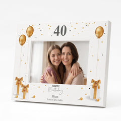 A white picture frame with a design of gold balloons and presents, along with the text "Happy Birthday" and " Mum Lots of love Julia" printed on it.