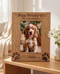 A wooden picture frame with a photo of a brown and white dog inside, accompanied by the text "Paw Prints on our hearts..." and the dog's name "Milo".