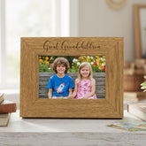 Wooden photo frame with 'Great Grandchildren' text, displaying a photo of two children on a table.