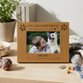 Wooden photo frame with engraved text and a picture of a boy and his dog on a wooden surface.