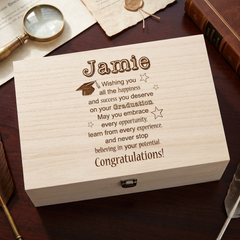 A wooden box with a personalized message engraved on it, placed on a wooden surface.