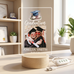 a graduation-themed photo frame with a photo of two women in graduation gowns, and the text "Graduation Amelia Smith 16.09.2026" is displayed on the frame.