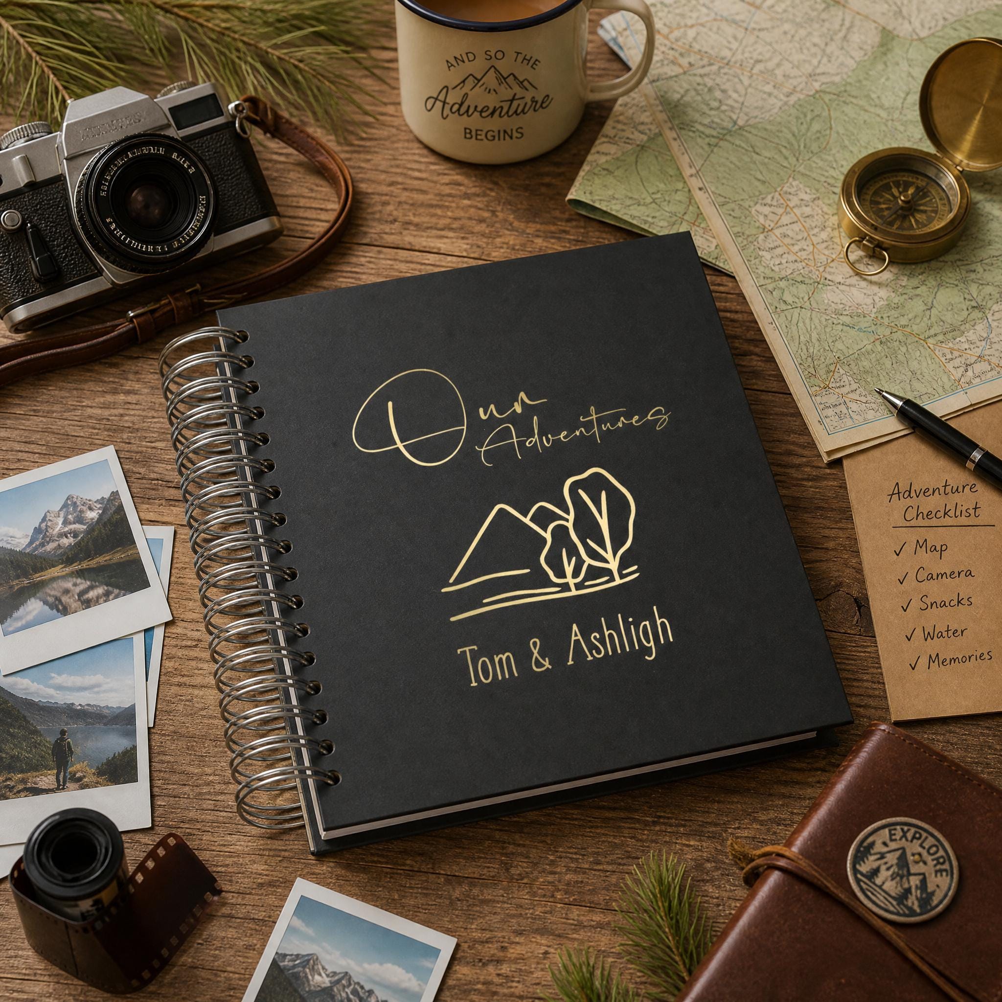 a collection of travel-related items, including a notebook with the text "Our Adventures Tom & Ashleigh", a camera, a map, a compass, a pen, and various photographs and souvenirs.
