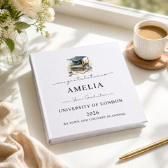a graduation cap and books on a white surface, along with a cup of coffee and a pen.