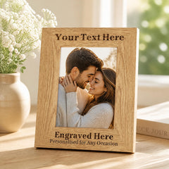A wooden picture frame with a photo of a couple embracing, and the frame has text engraved on it.