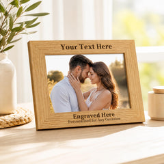 A wooden picture frame with a photo of a couple embracing, and the text "Your Text Here" and "Engraved Here" printed on it.