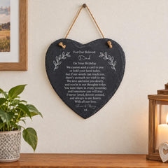 A heart-shaped slate hanging on a wall, with a heartfelt message written on it.