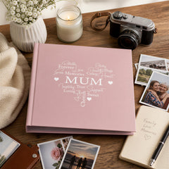 a pink photo album with the word "MUM" written on it, surrounded by various personal items such as a camera, a candle, and a notebook with handwritten notes.