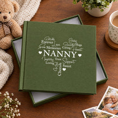 a green box with the word "NANNY" written on it, surrounded by various objects such as a teddy bear, a mug, and some flowers.