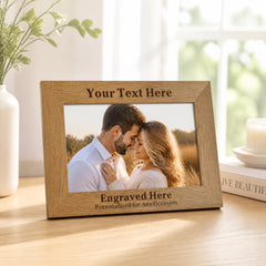 A wooden picture frame with a photo of a couple embracing, placed on a wooden surface. The frame has a personalized message engraved on it.