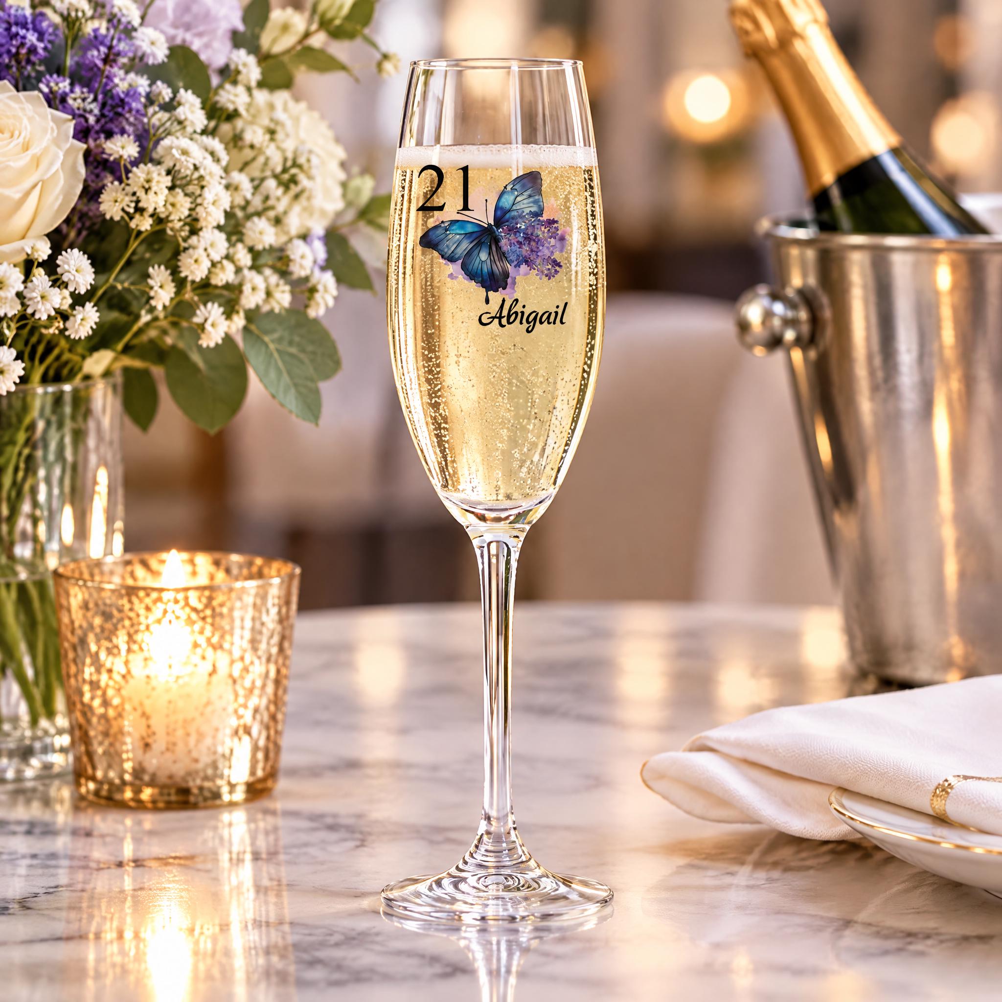 a table with a champagne glass containing champagne, a candle, and a vase of flowers.