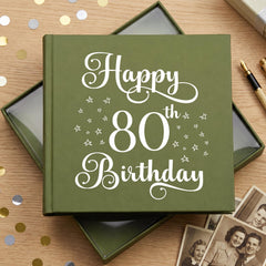 A green photo album with the text "Happy 80th Birthday" printed on it, surrounded by confetti and some photographs.