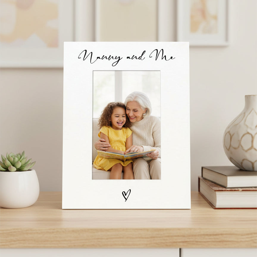 Personalized photo frame with 'Nanny and Me' text on a shelf with decor items.