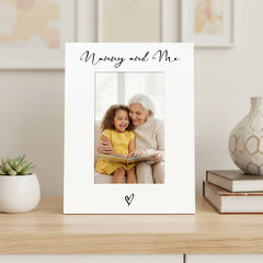 Personalized photo frame with 'Nanny and Me' text on a shelf with decor items.