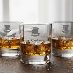 Four whiskey glasses with branding on a wooden surface